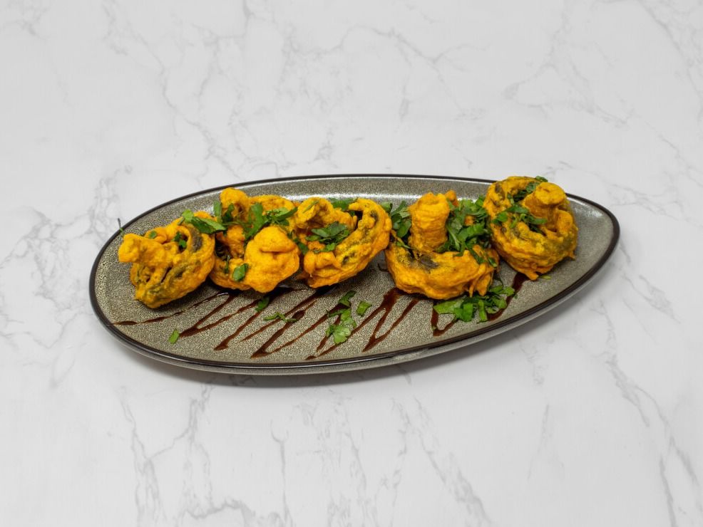 Golden vegetable pakora on a stone plate